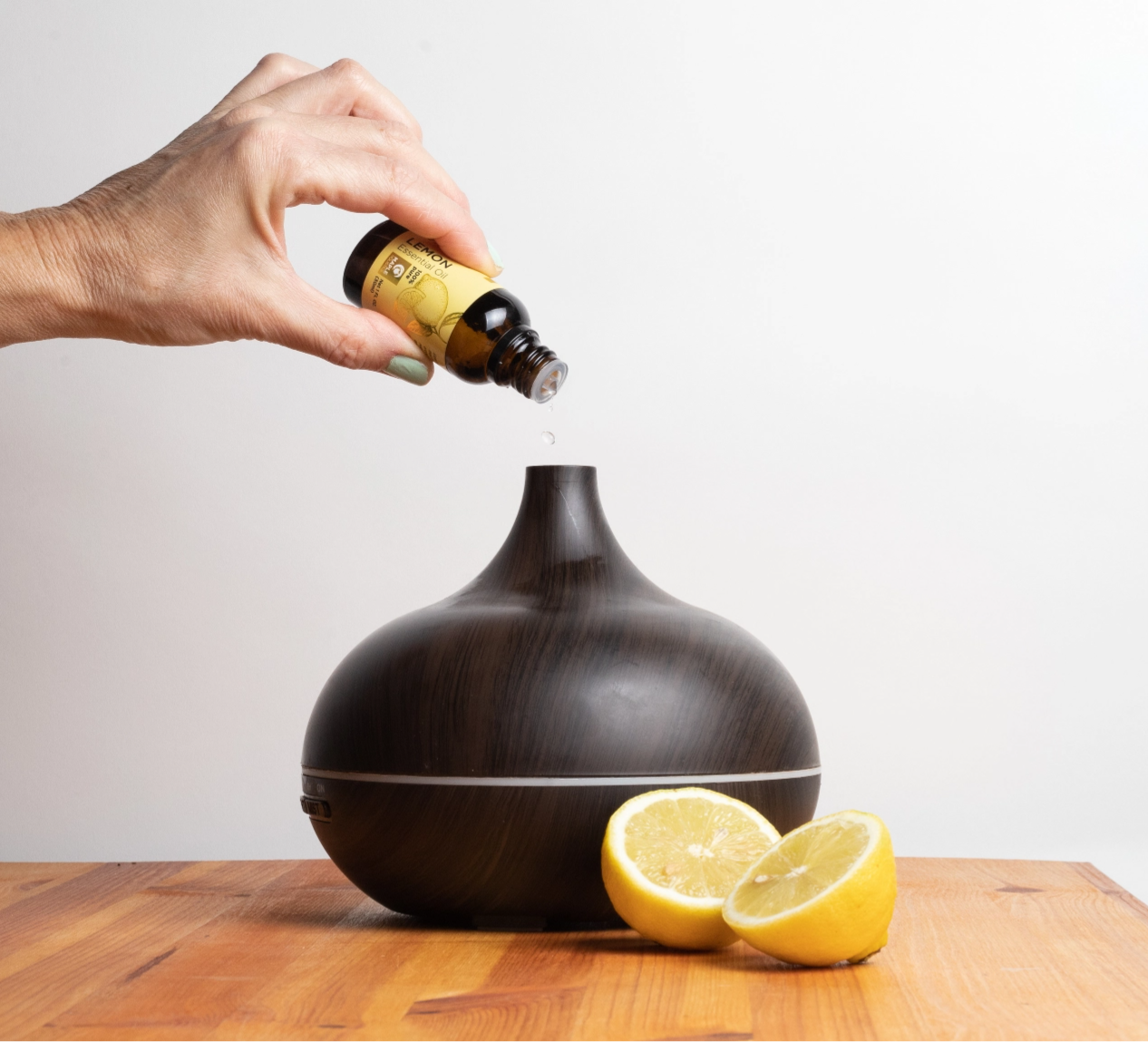 Maple Holistics Lemon Essential Oil being added to a diffuser